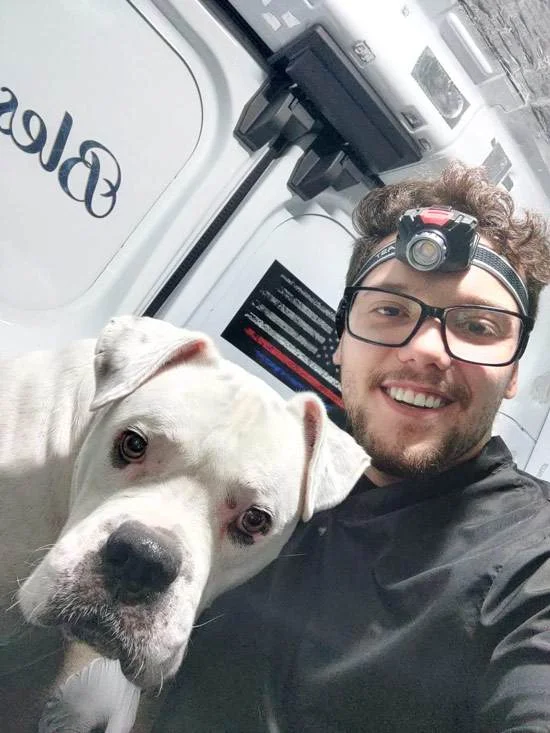 Royal Touch technician posing with a white pit bull outside the mobile unit