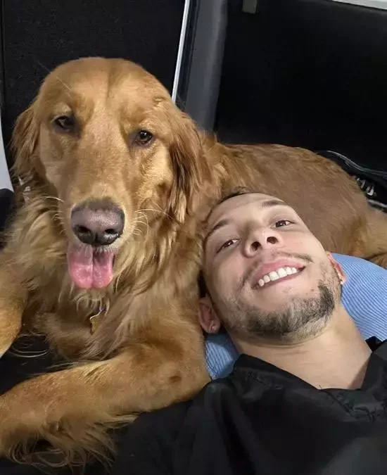Royal Touch technician relaxing with a golden retriever after dental cleaning