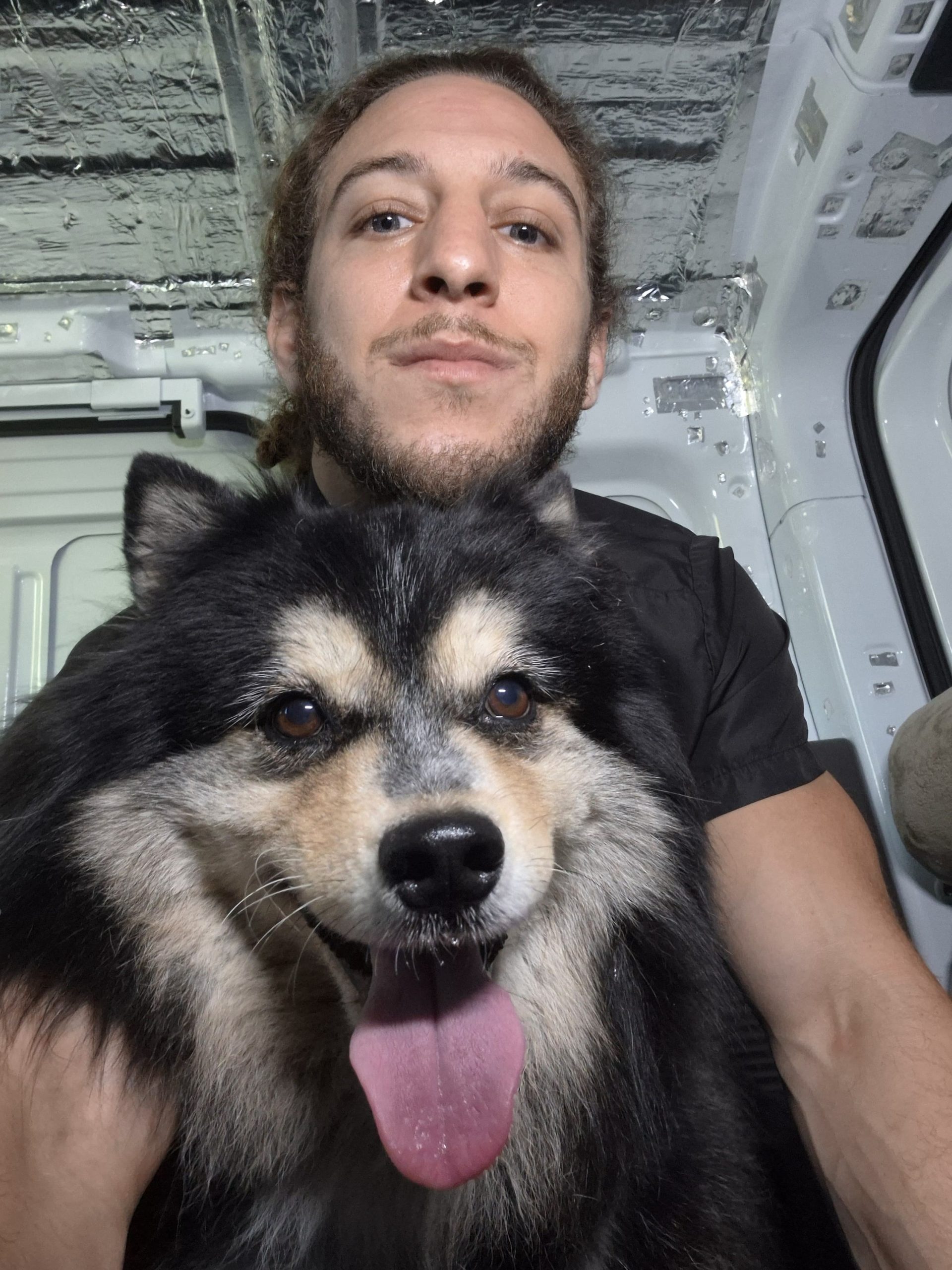 Royal Touch team member with a fluffy black and white dog in the dental van
